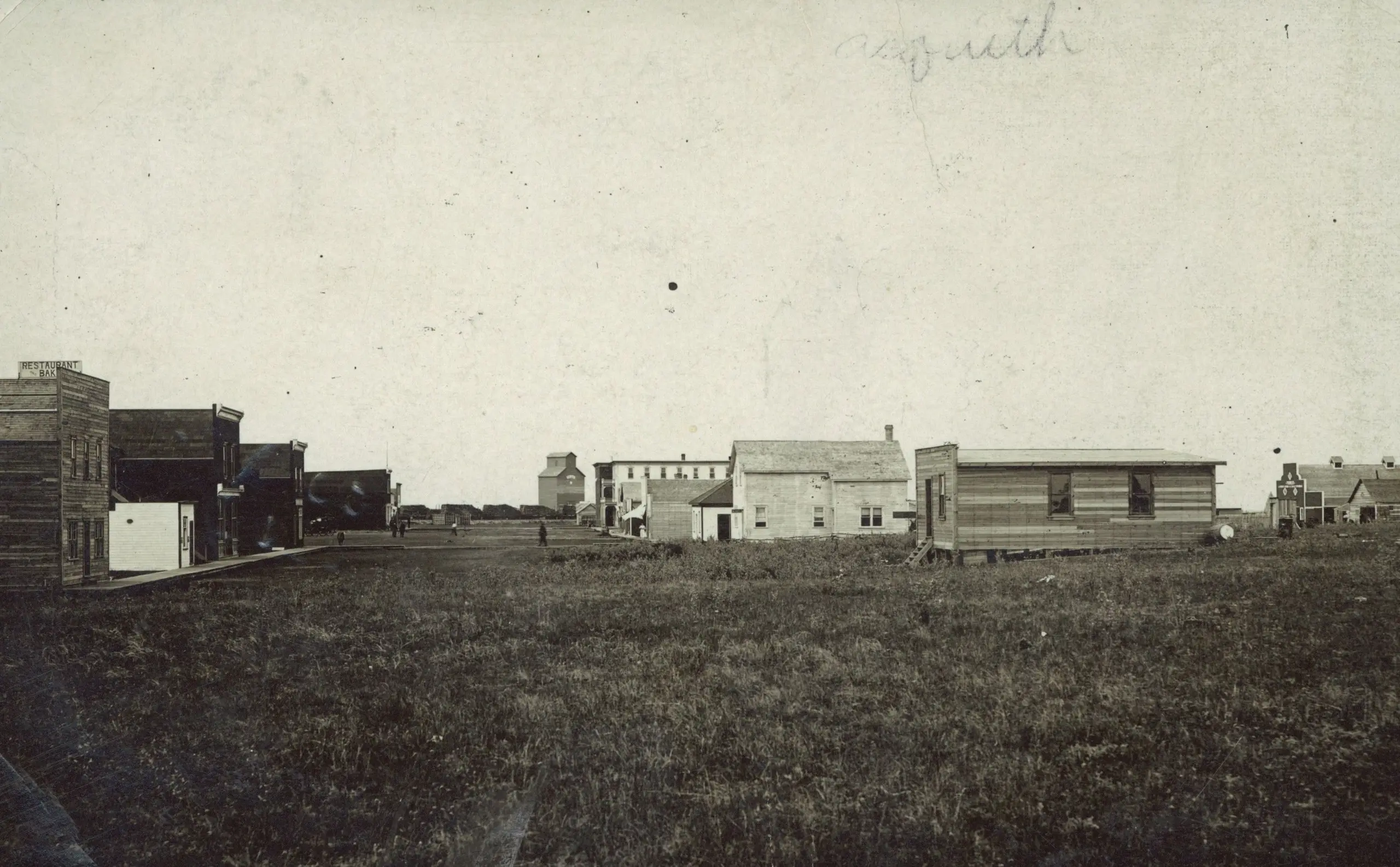Early street scene with wooden buildings and grain elevator
