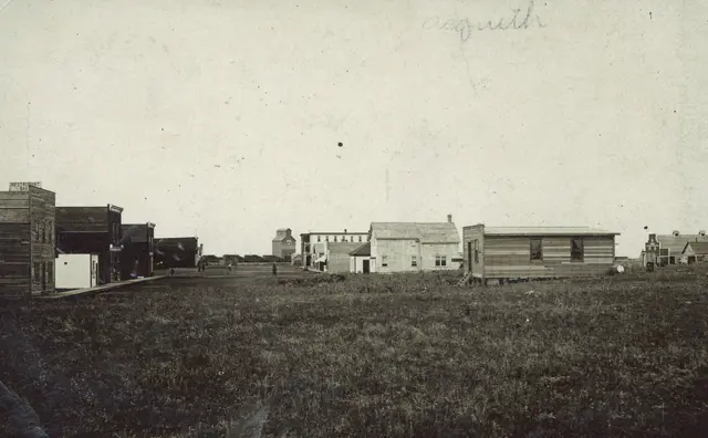 Early street scene with wooden buildings and grain elevator